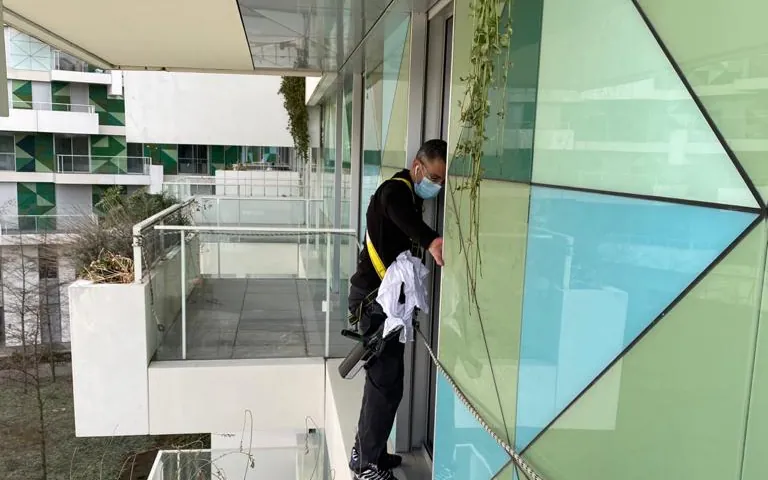 Façade vitrée : descente en rappel, vitrage et structure dans le même passage.