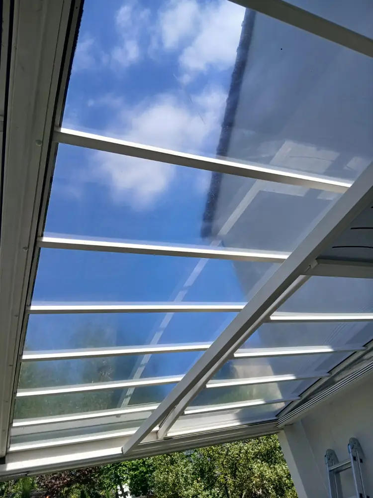 Toiture de carport redevenue transparente, ciel bleu visible