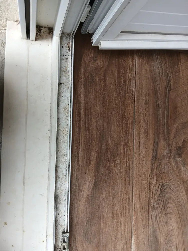 Coulisse de baie vitrée obstruée par la terre et les débris