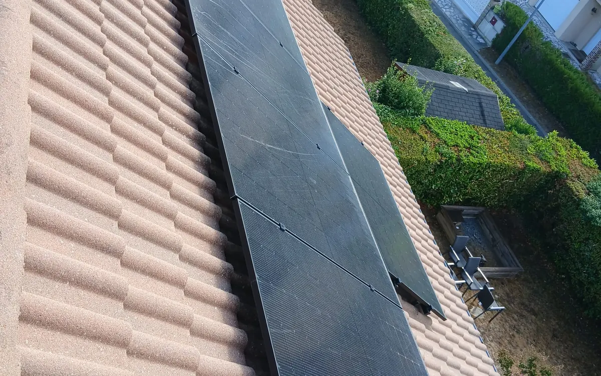 Panneaux photovoltaïques ternis par les dépôts sur une toiture en tuiles